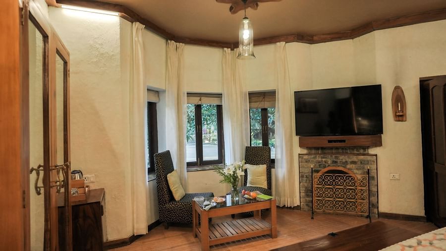 A living room with a couch, a television, and warm lighting, wooden interior - The Den Corbett Resort & Spa, Kumeria.