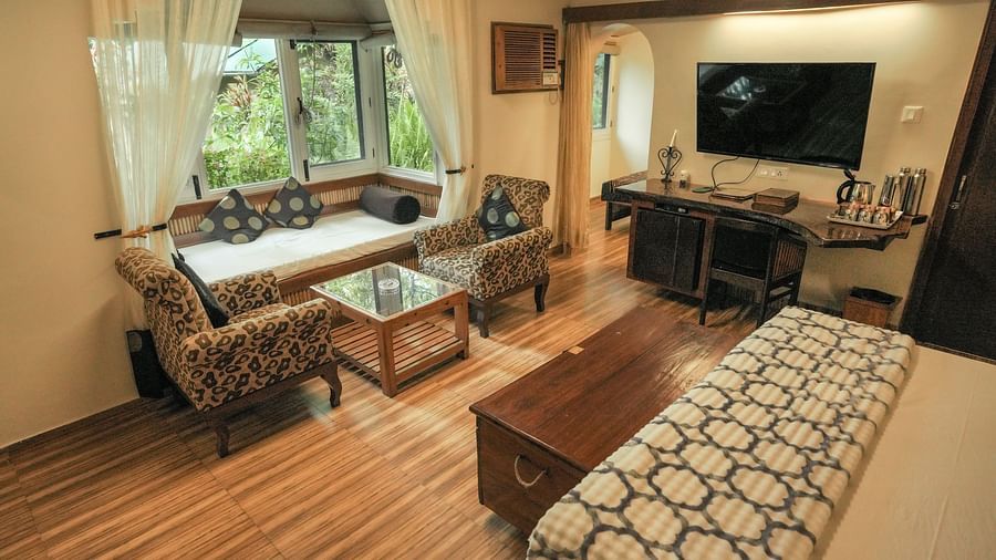 A living room with a couch, a television, and warm lighting, wooden interior - The Den Corbett Resort & Spa, Kumeria.