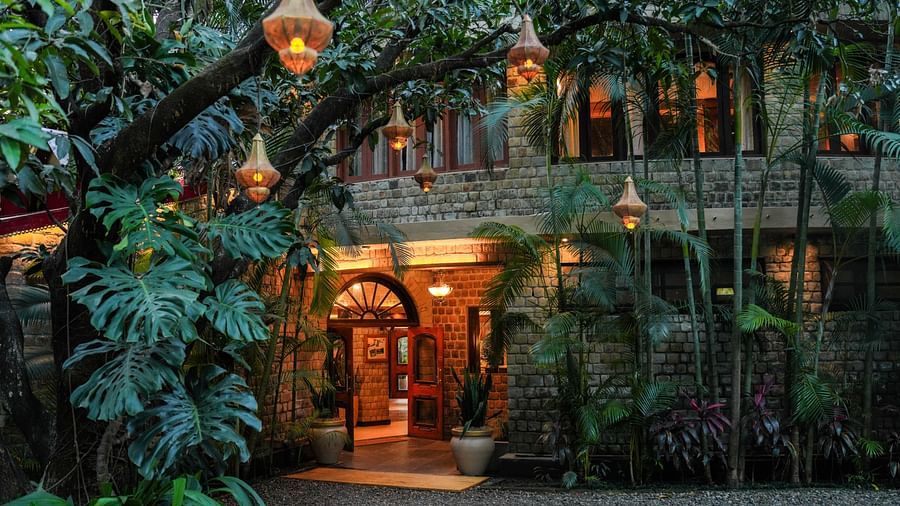 A multi-level building with lights and hanging lanterns, surrounded by trees at night.