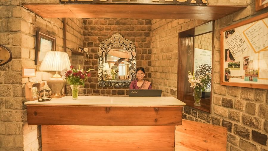A reception desk with a wooden counter and a RECEPTION sign, warm lighting, interior setting.