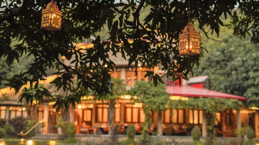 A multi-level building with lights and hanging lanterns, surrounded by trees at night.