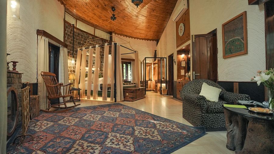 A hallway with a patterned rug, a couch, and warm lighting, wooden interior - The Den Corbett Resort & Spa, Kumeria.