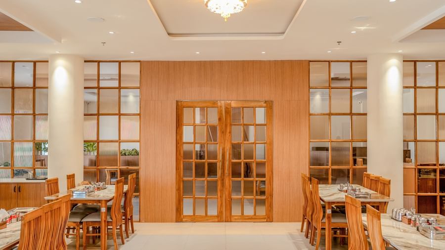 A beautiful entrance door at Daksh The Grand Goverdhan, Dwarka, with a small chandelier hanging from the ceiling above the pathway.