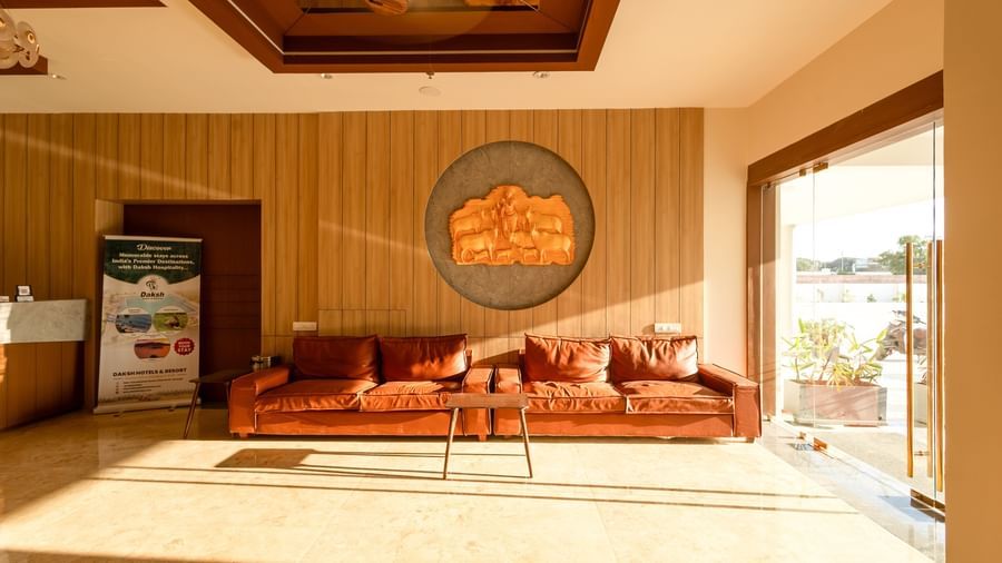 Front shot of the plush leather couch in the lobby area of Daksh The Grand Goverdhan, Dwarka, with ample of natural light coming from outside.