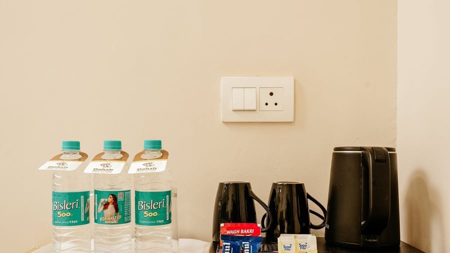 Refreshment station at the Pride Room at Daksh The Grand Gowardhan, Dwarka, with bottled water and a kettle.