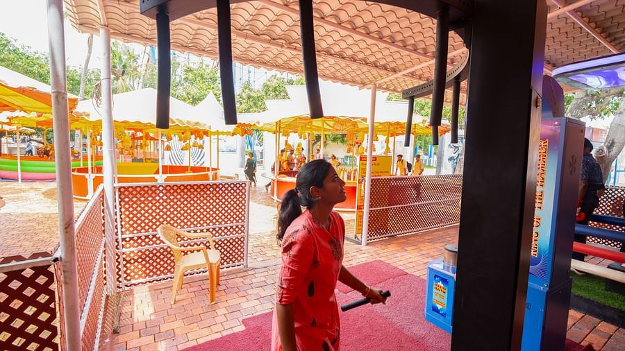 A Woman with a stick trying to jump towards a ride which is meant for hanging at MGM Dizzee World.