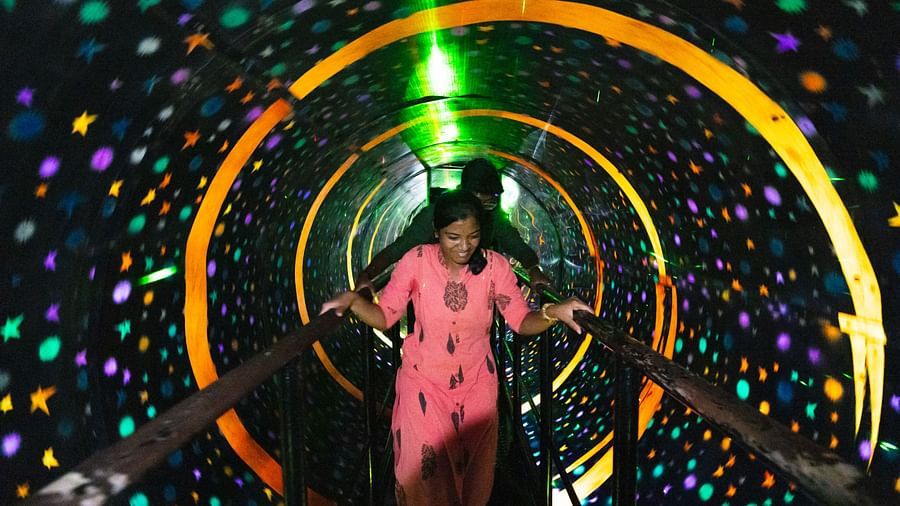 A Vortex room at MGM Dizzee World featuring people walking on a bridge and around it everything is rotating. It creates an illusion that the bridge is rotating.