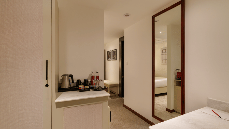 Superior Room at Shilton Suites, Bengaluru showing the vanity area, wardrobe, tea and coffee facilities and part of the bedroom.