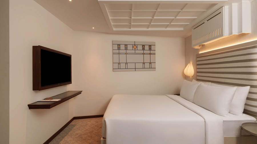 Superior Room at Shilton Suites, Bengaluru featuring a king size bed, wall mounted television, bedside lighting and modern interiors.