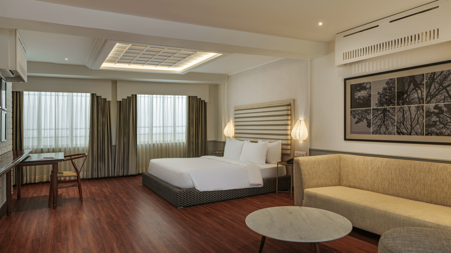 Spacious Terrace Suite at Shilton Suites, Bengaluru, featuring a king size bed, lounge seating, work desk, and large windows.
