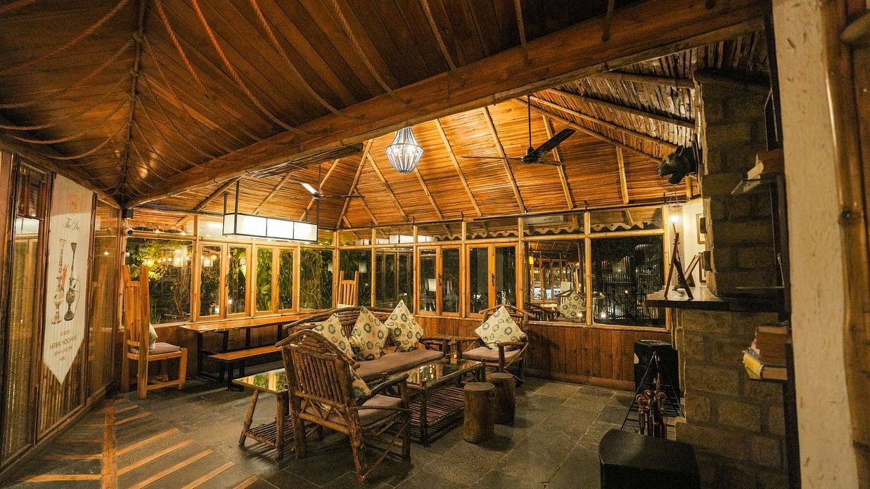 A room with wooden beams and warm lighting, possibly a dining area.