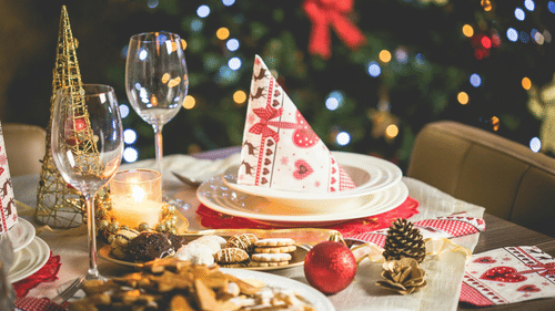 A festive table is set for a Christmas dinner with food and decorations.