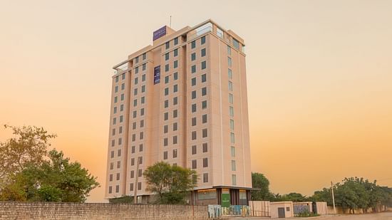 Facade of Clarks Inn Suites Jaipur, Ajmer Road in the late afternoon under a peach-orange sky