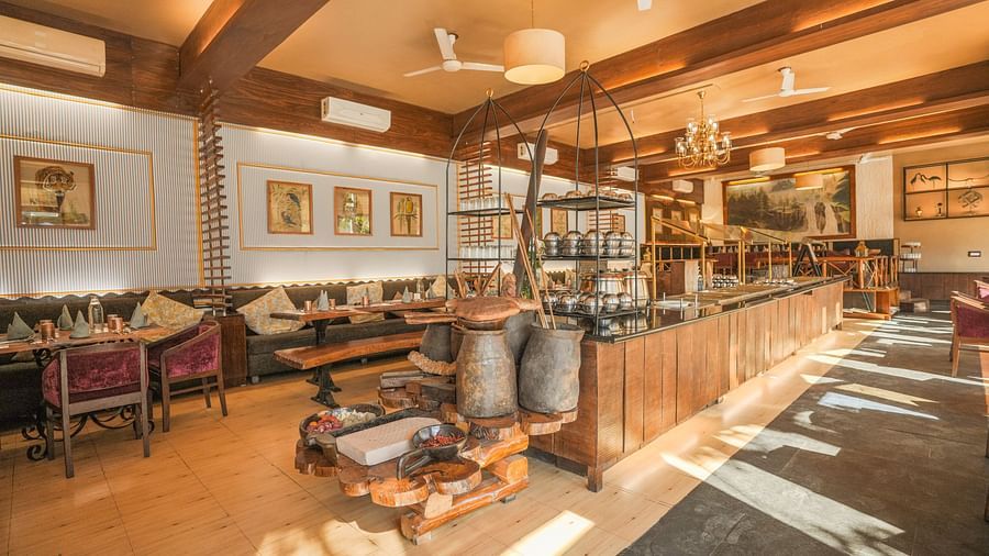 A restaurant interior with a bar, tables, and chairs, warm lighting.