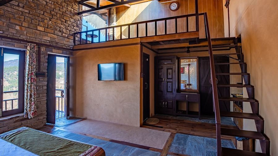 Spacious rustic room featuring a loft, wooden beams, and natural light streaming through windows. - Blusalzz Homes The Himalayan Bungalow, Almora