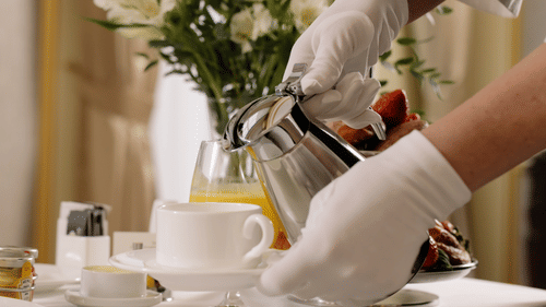 A waiter pouring tea in a cup