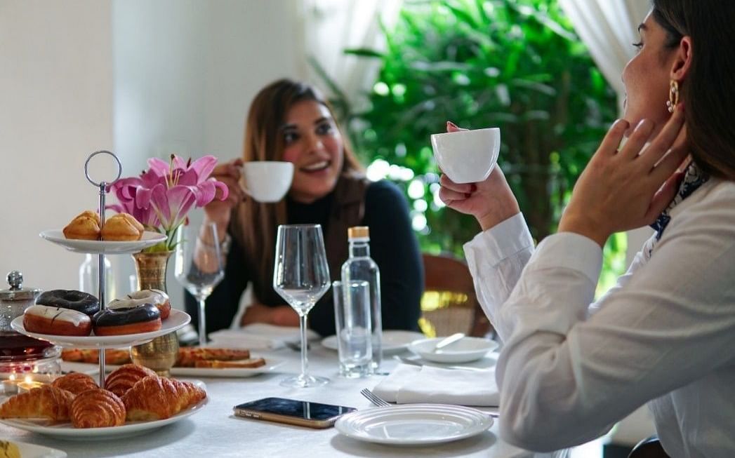 Two women having a conversation at a breakfast table arrangement at Saraca Hotel, Lucknow