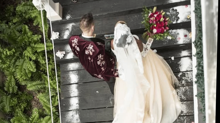 Overhead view of a couple walking on a wooden deck surrounded by greenery | A Stone's Throw Away