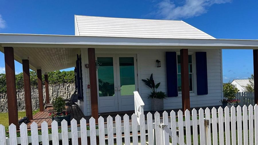 One-story house with a picket fence surrounding the front yard. Shutters frame the windows and a palm tree is visible to the left | Abaco Inn