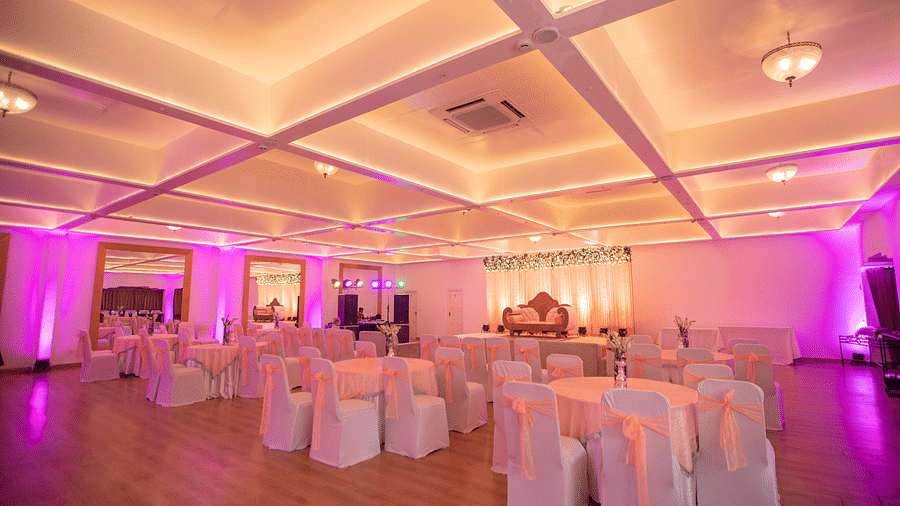 Seating arrangement in a banquet hall at Saraca Hotel, Lucknow with pink lighting 