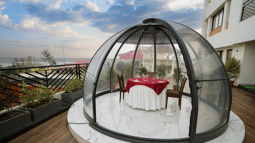 a half bubble kind of architecture with a table for two set inside it on the terrace at Shanti Seaview Resort & Spa - Hotels in Mandarmani Sea Facing