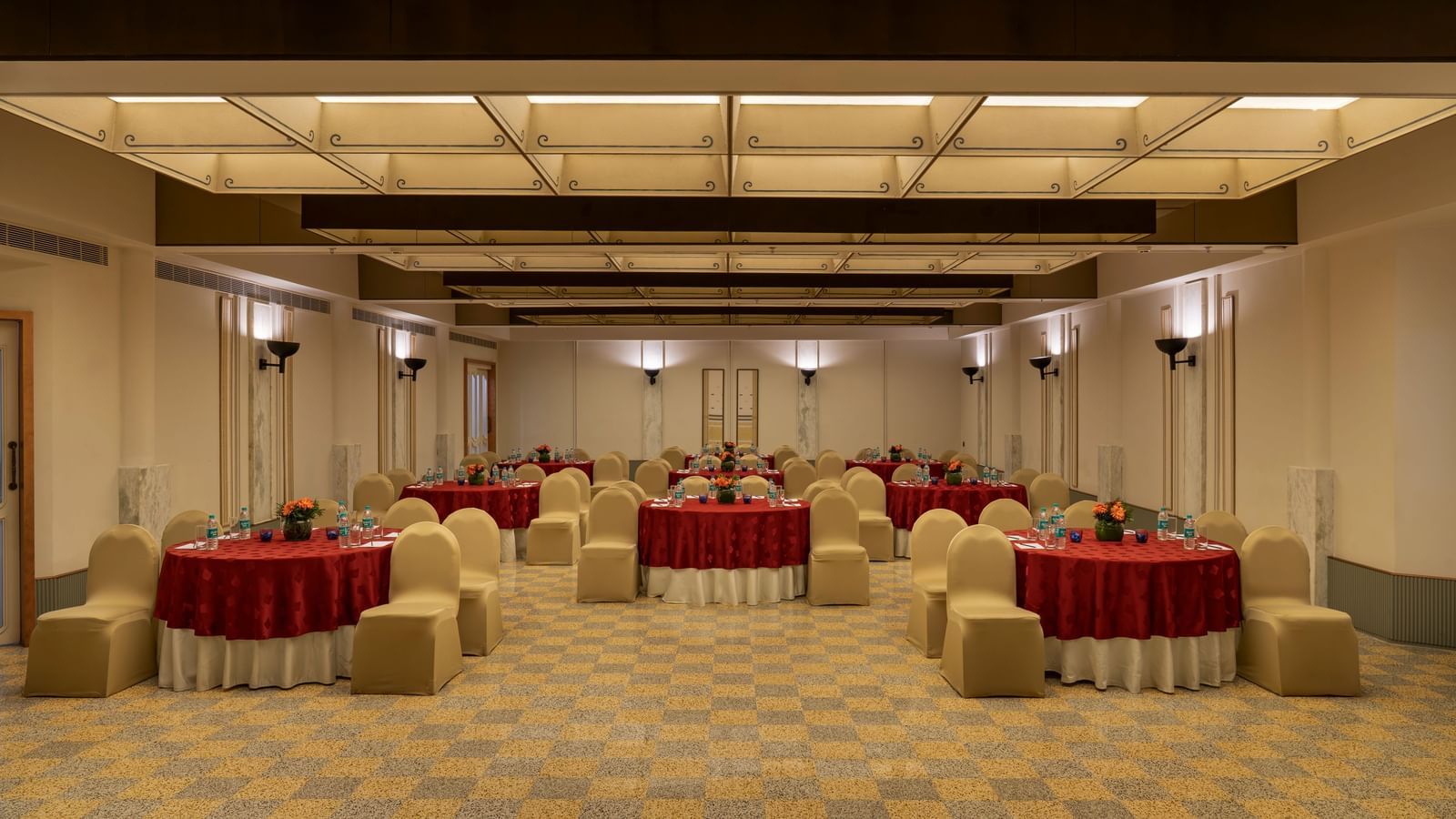  A banquet hall at Shilton International, Kochi, set with round tables and chairs for a gathering.