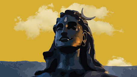 A large, black statue of Adiyogi with a mountain range in the background.