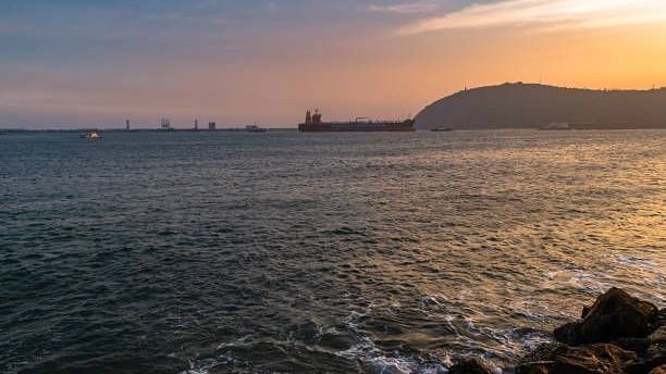 A serene ocean view with the sun setting on the horizon, casting golden hues over the water