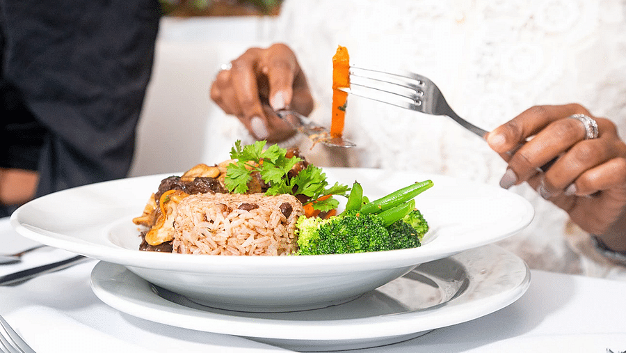 A woman dressed in white enjoying a sandwich in our restaurant in Kingston - S Hotel Kingston, Jamaica