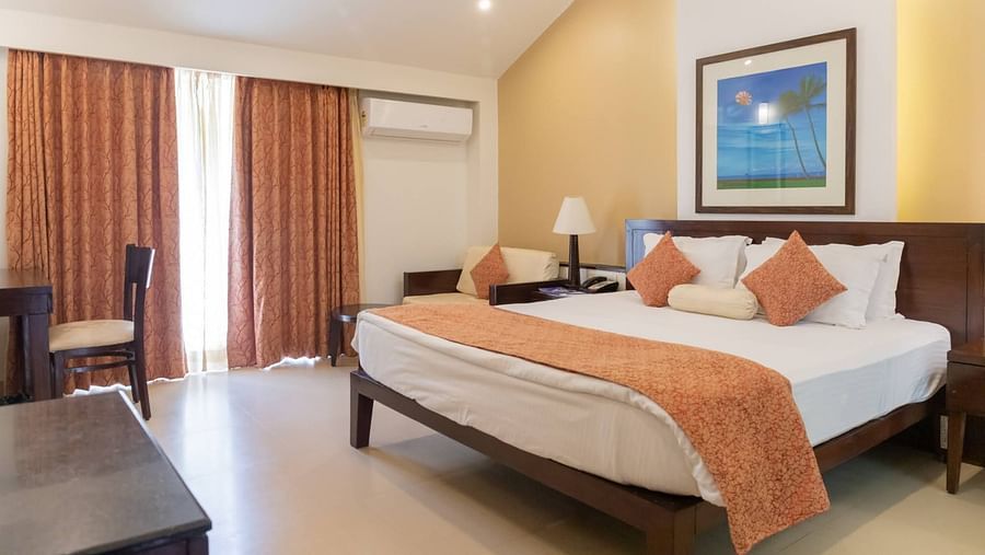 The king size bed in the premier room with peach coloured blanket at Kyriad Prestige Calangute, Goa