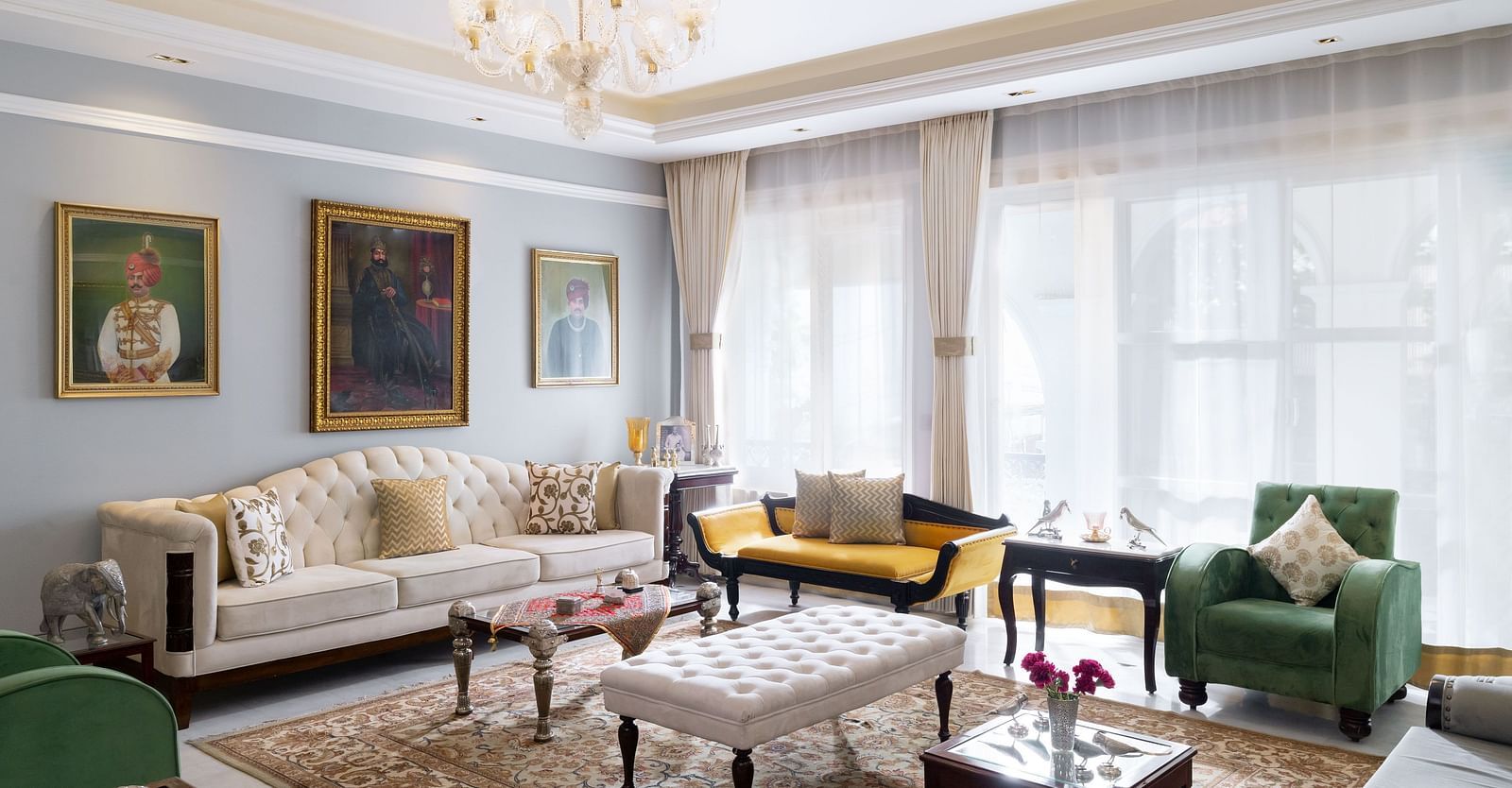 Guest lounge area at Dileep Kothi, Jaipur with sofa arrangement and photographs hung on the walls