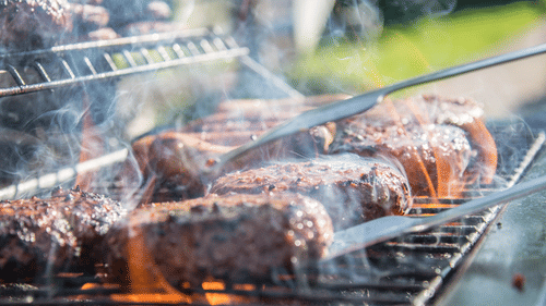 many pieces of meat being grilled on a barbeque stand 