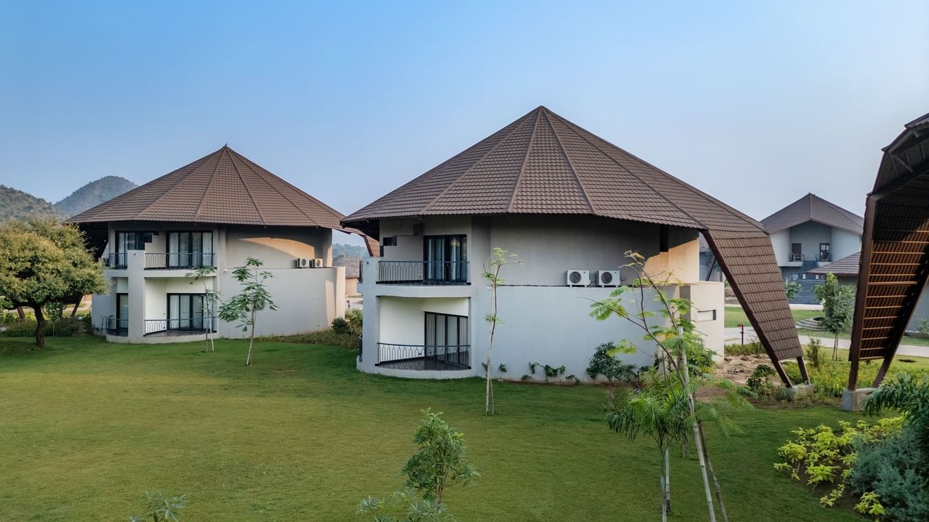 Exterior of Fire Villas at Ananta Spa & Resort, Ajabgarh, situated with grass lawn around, and as seen on a day with clear sky.