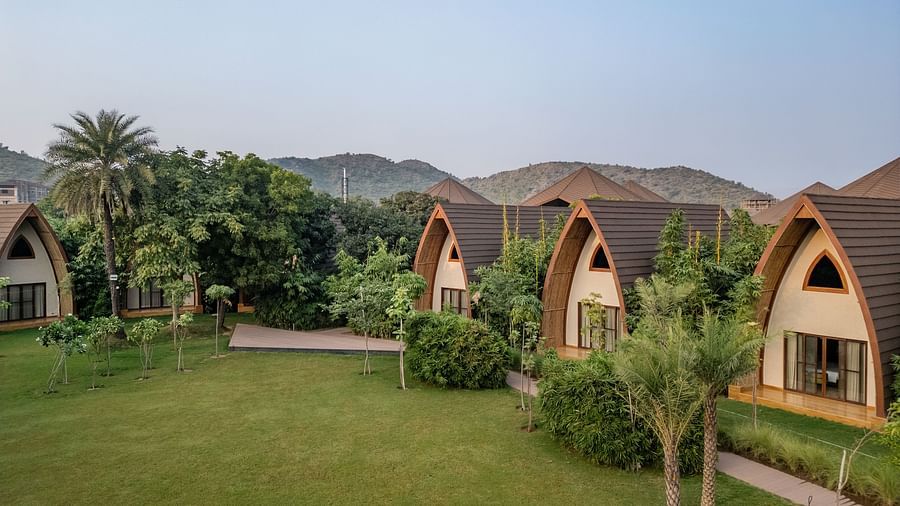 An image of a hut style villas amidst the palm trees in a resort