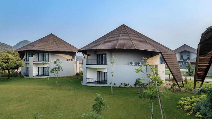 Exterior of Fire Villas at Ananta Spa & Resort, Ajabgarh, situated with grass lawn around, and as seen on a day with clear sky.