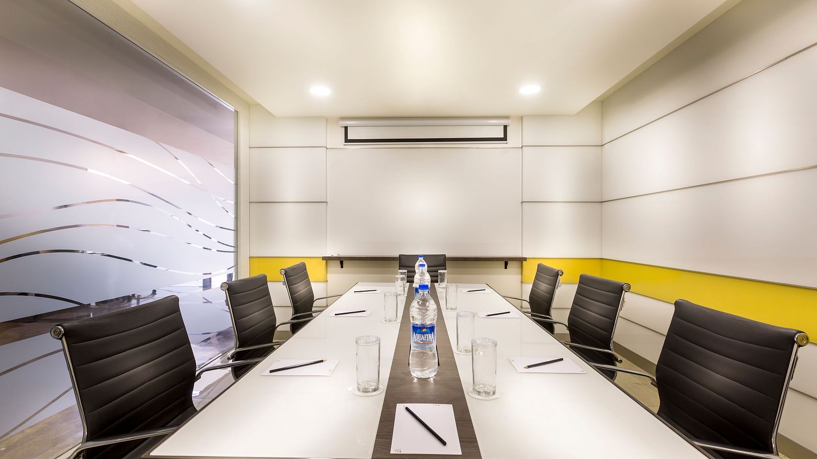 An image of the Board Room with black chairs placed next to each other in front of a white table at Regency Tiruttani by GRT Hotels.