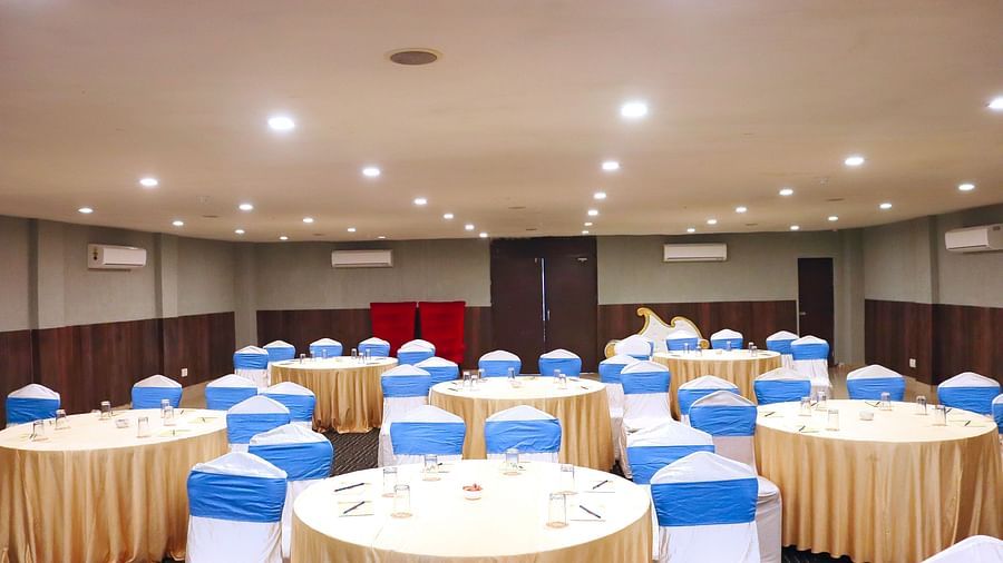 The banquet hall is set up with round seating tables at Clarks Collection, Bhavnagar