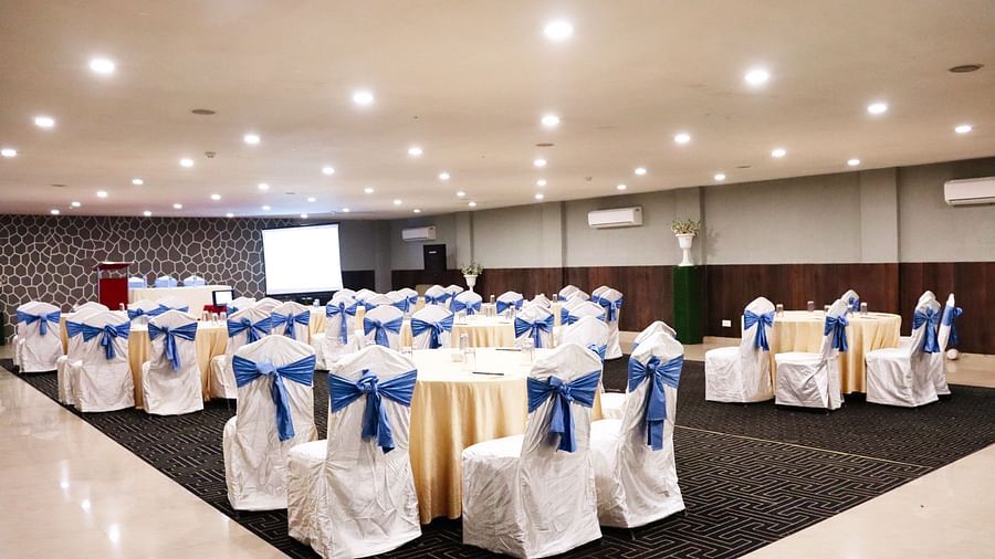 The banquet hall is set up with round seating tables at Clarks Collection, Bhavnagar