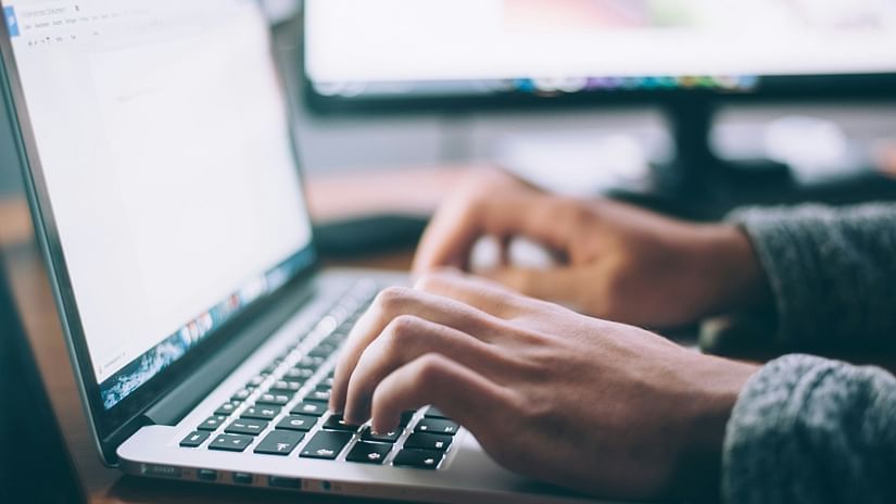 A person typing on a macbook.