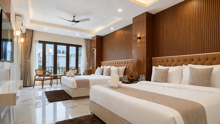 A Family Suite AC Room at Valmere Chery Blossom Suites with 2 spacious beds, elegant modern interiors, a wall-mounted television and a ceiling fan.