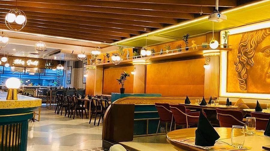 An image of chairs and tables and ceiling lights at Themis Barbecue House, Panipat