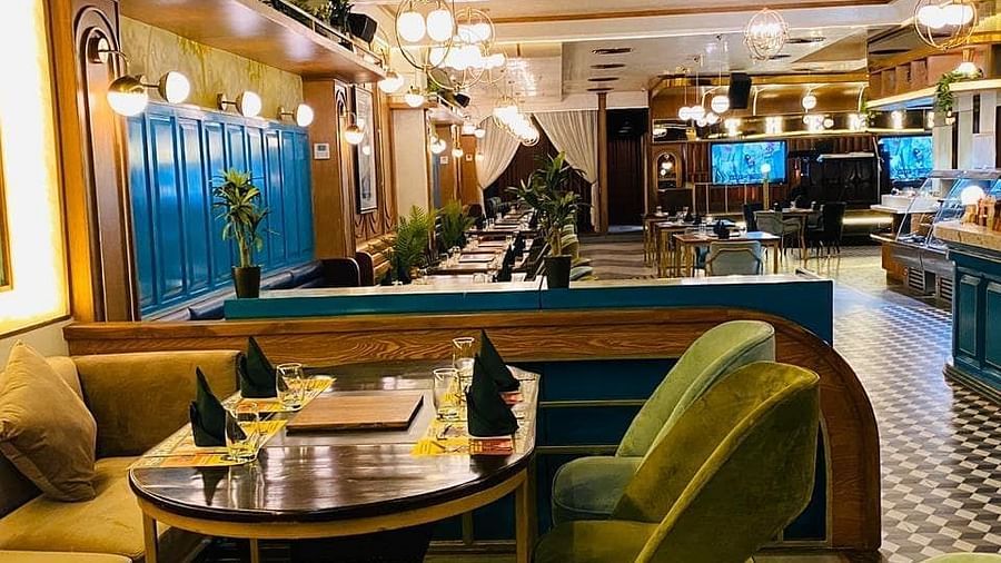 An image of a dining table set featuring chairs and tables at every corner of the hall - Themis Barbecue House, Panipat