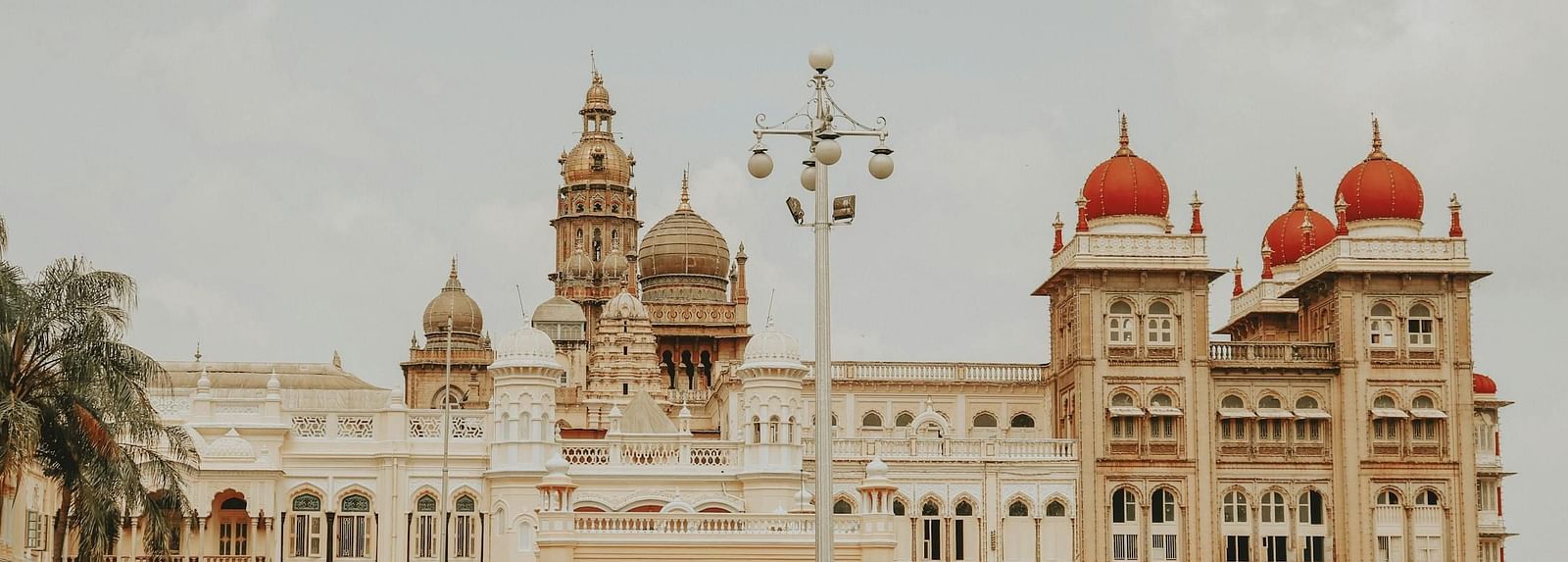 The facade of Mysore Palace with plants adorning the area in front.
