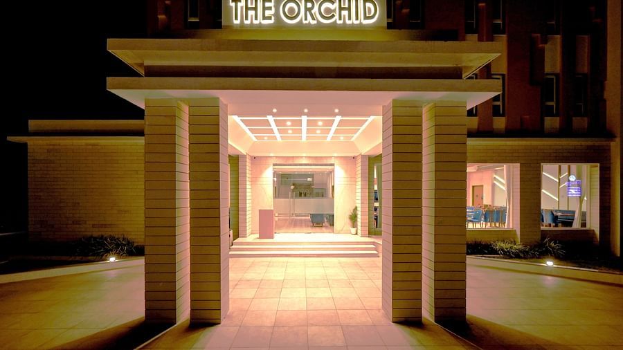 Entrance to the hotel with the signage of The Orchid above in the night - The Orchid Hotel, Jamnagar