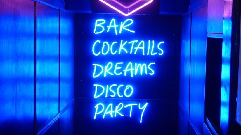 a neon sign with the words Bar, cocktails, dreams, disco & party written 