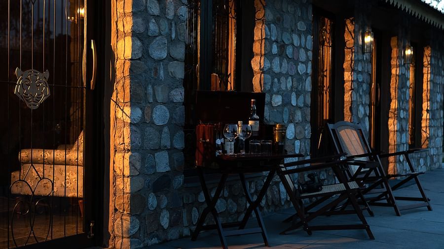 An image of a structure made of stones with chairs in front of it seen during an evening - Aalia Jungle Resort & Spa