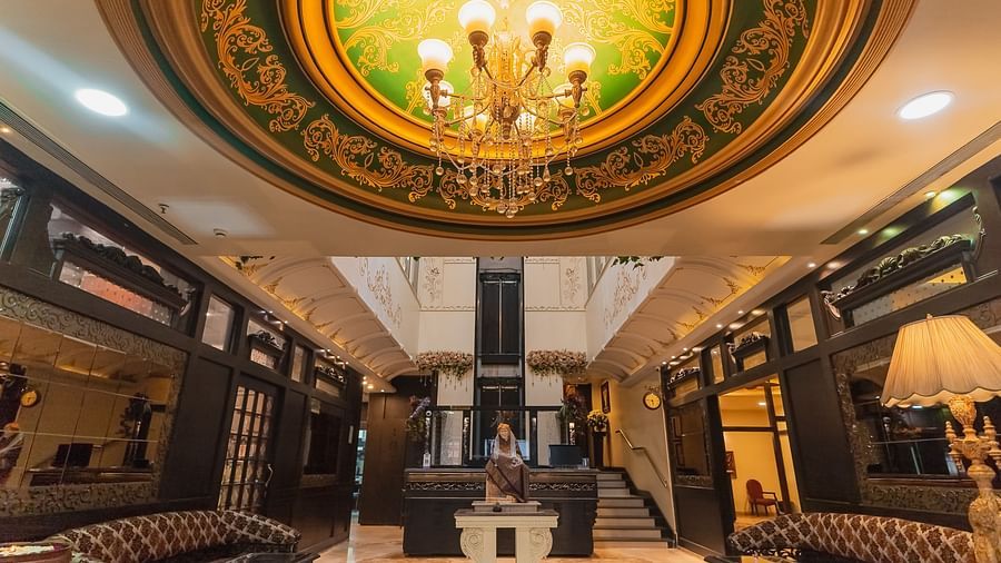 Hotel Ashok Nagpur featuring a well-lit lobby with dark wood accents, plush seating, and a reception area.