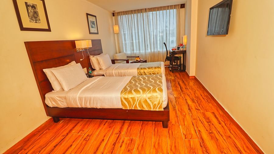 Side view of the twin beds in deluxe twin room with all basic amenities - Clarks Collection, Vadodara