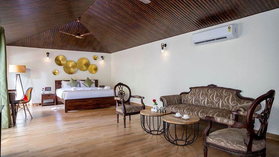 A spacious bed positioned beneath a decorative wallpaper, accompanied by comfortable sofas for relaxation in the room