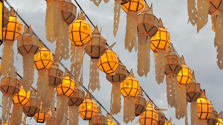 Multiple handmade lanterns hung on a thread in a row to mark Loy Krathong.